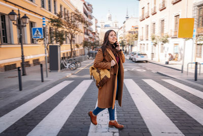 Full length of woman standing on street in city