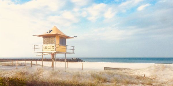 Lifeguard hut on beach against sky