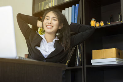Portrait of a smiling young woman sitting on table