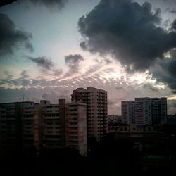 Buildings against cloudy sky