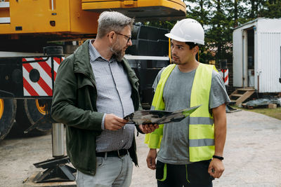 Foreman and customer or client agree about future building work on construction site. architect