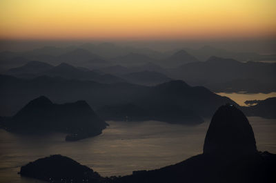 Aerial view of sugarloaf mountain in sea against sky during sunrise