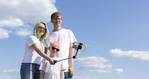 Caucasian family takes selfie. parent and child with colorful dye at birthday party or celebrating