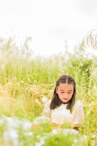 Portrait of young woman sitting on field