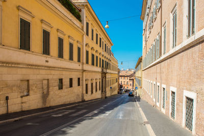 Road amidst buildings in city against clear sky