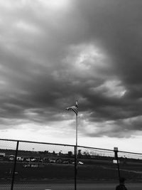 Railing against cloudy sky