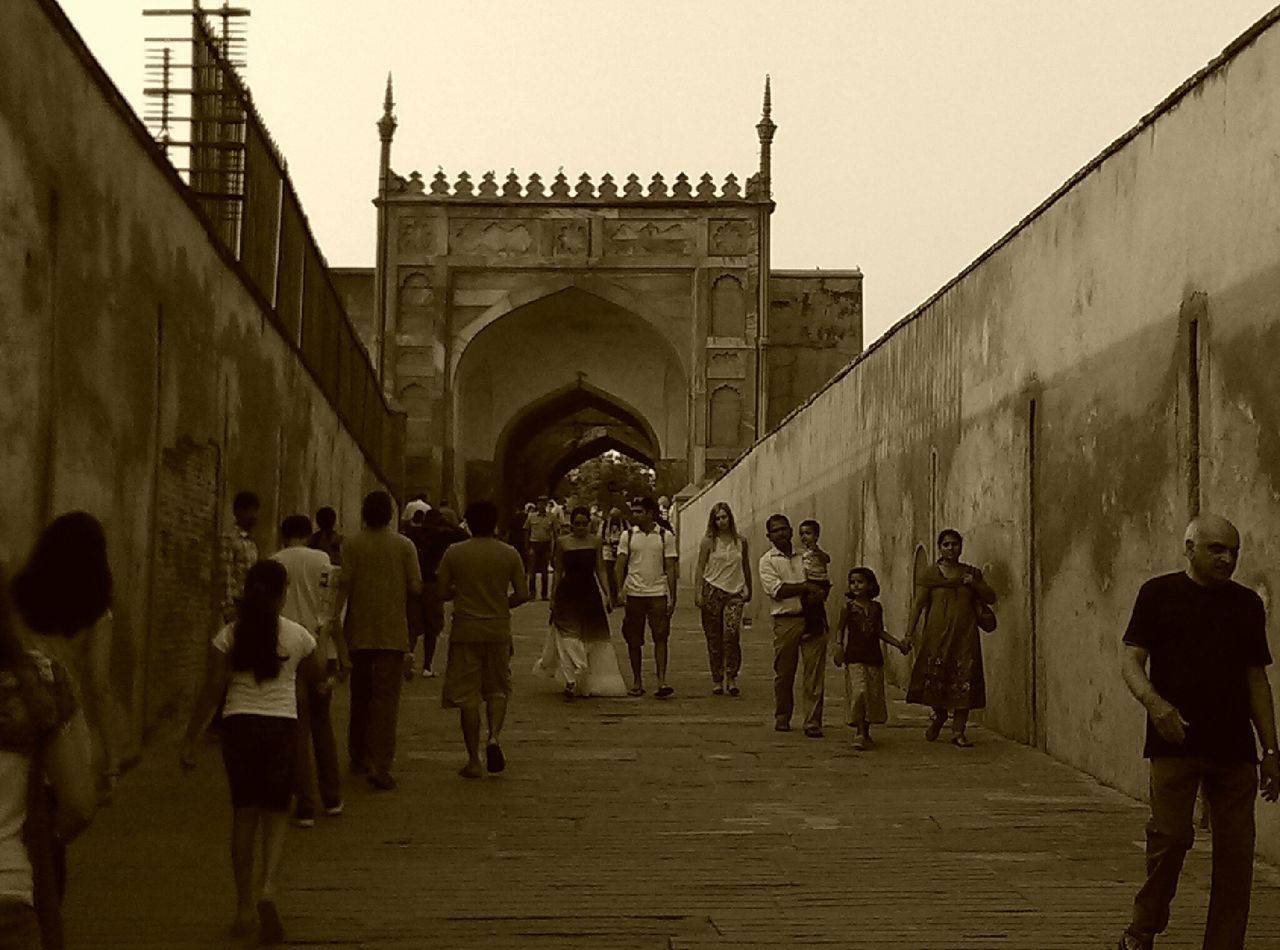 architecture, built structure, men, building exterior, large group of people, walking, person, lifestyles, leisure activity, the way forward, clear sky, full length, travel destinations, travel, famous place, tourist, history, arch, rear view