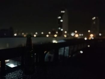 Defocused image of illuminated city against sky at night