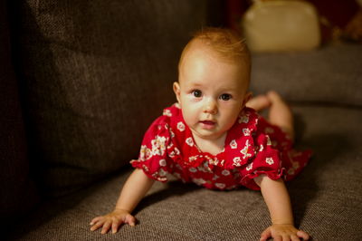 Closeup portrait of cute little baby girl lying on a sofa