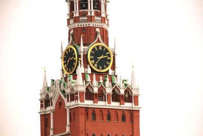 Low angle view of clock tower in city against clear sky