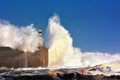 Panoramic view of waves breaking against sky