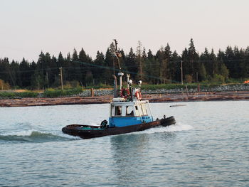 People in boat on river against sky