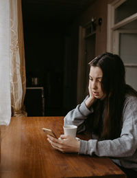 Portrait of young woman sitting at home