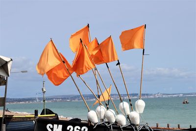 Umbrellas by sea against clear sky