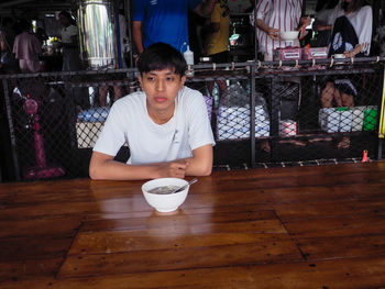 Portrait of boy sitting on table