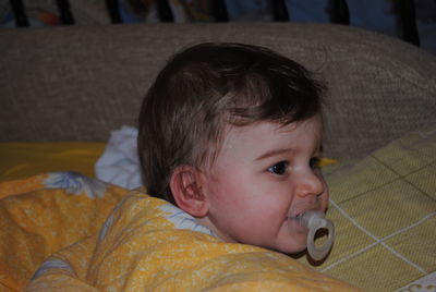 Portrait of cute baby relaxing on bed at home