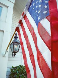 Low angle view of flags hanging against built structure