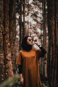 Standing against trees in forest