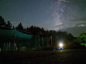 Scenic view of illuminated field against sky at night