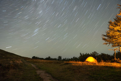 Tourist tent on a hill overlooking the night sky