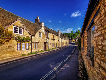 Road amidst buildings against sky