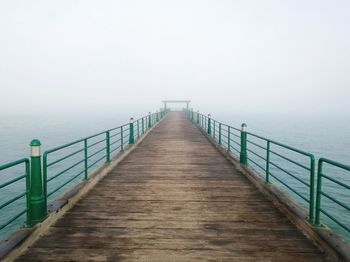 Pier over sea in foggy weather