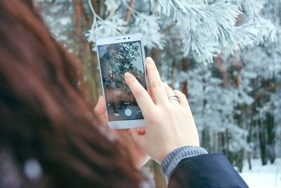 Midsection of person photographing with mobile phone