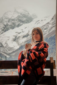 Young woman standing on snow covered mountain