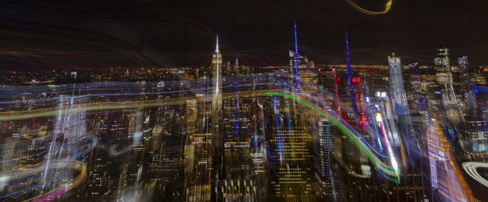 Light trails on street amidst buildings in city at night