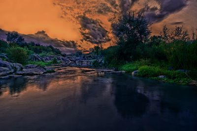 Scenic view of river against sky at sunset