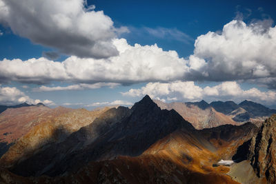 Scenic view of snowcapped mountains against cloudy sky