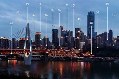 Digital composite image of illuminated buildings against sky
