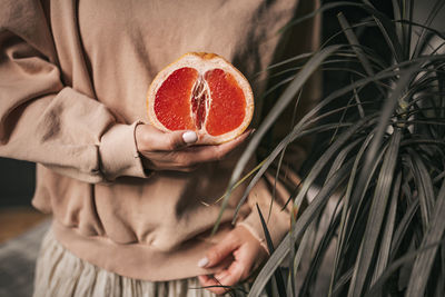 Midsection of woman holding strawberry