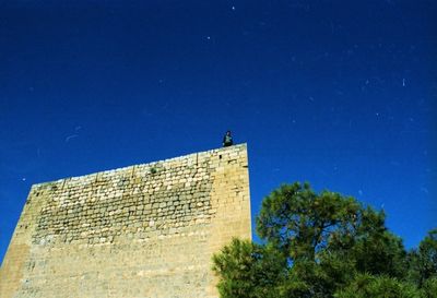 Low angle view of built structure against clear blue sky