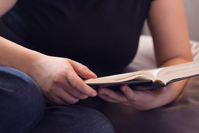 Midsection of woman reading book