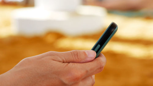 Close-up of hand holding mobile phone