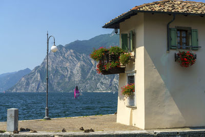 House by sea and mountains against sky