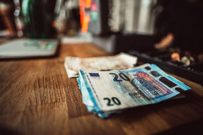 High angle view of paper currencies on wooden table