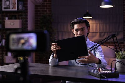 Young woman using laptop at cafe