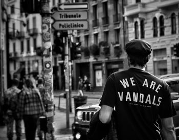 Rear view of man standing on street in city