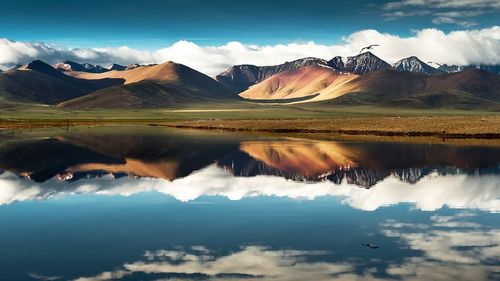 Scenic view of lake and mountains against sky