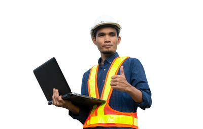 Low angle view of man using mobile phone against clear sky