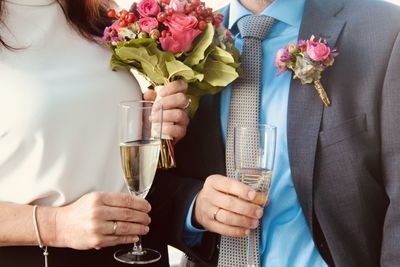 Midsection of people holding flower bouquet