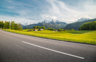 Landscape and mountains by road against sky