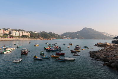 Boats moored in sea against clear sky