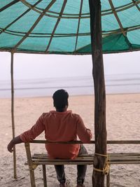 Rear view of man standing on beach