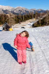 Portrait of girl on snow covered mountain against sky