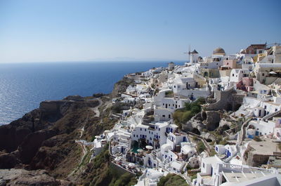 High angle view of town by sea against clear sky