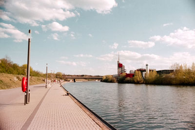 Scenic view of river by buildings against sky