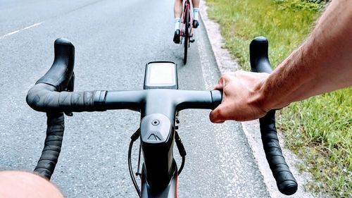 Cropped image of man riding bicycle on road